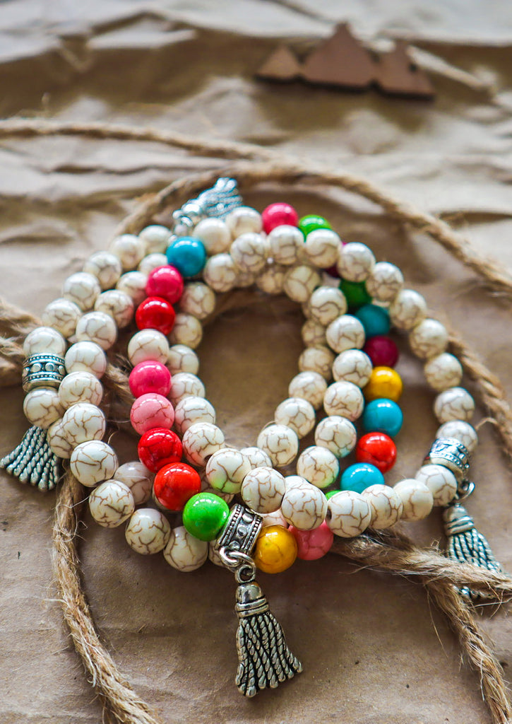 Three cream marble bracelets with candies bracelet on a Kraft paper background 