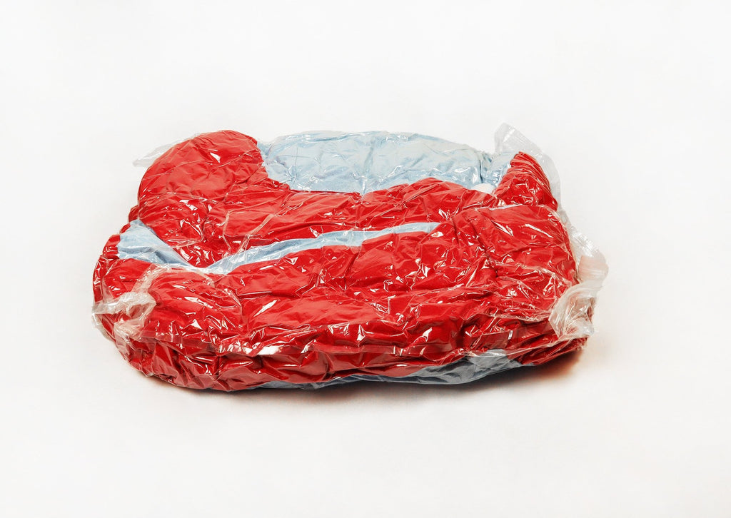 Cuddler bed in vacuumed bag on white background 