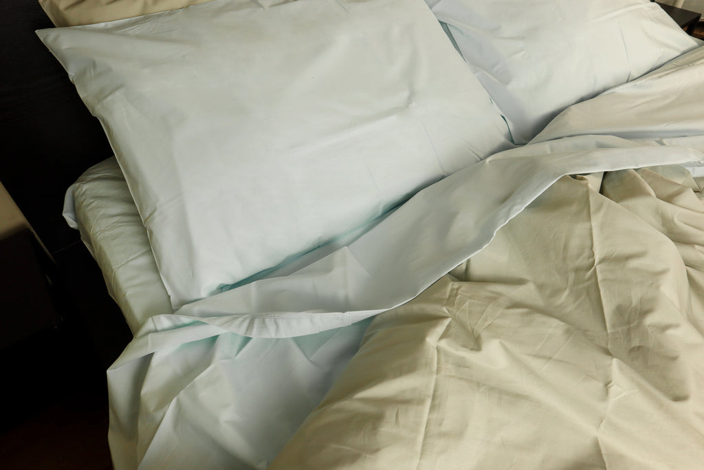 photo from above for a bed with powder blue sheet set and silver beige duvet cover