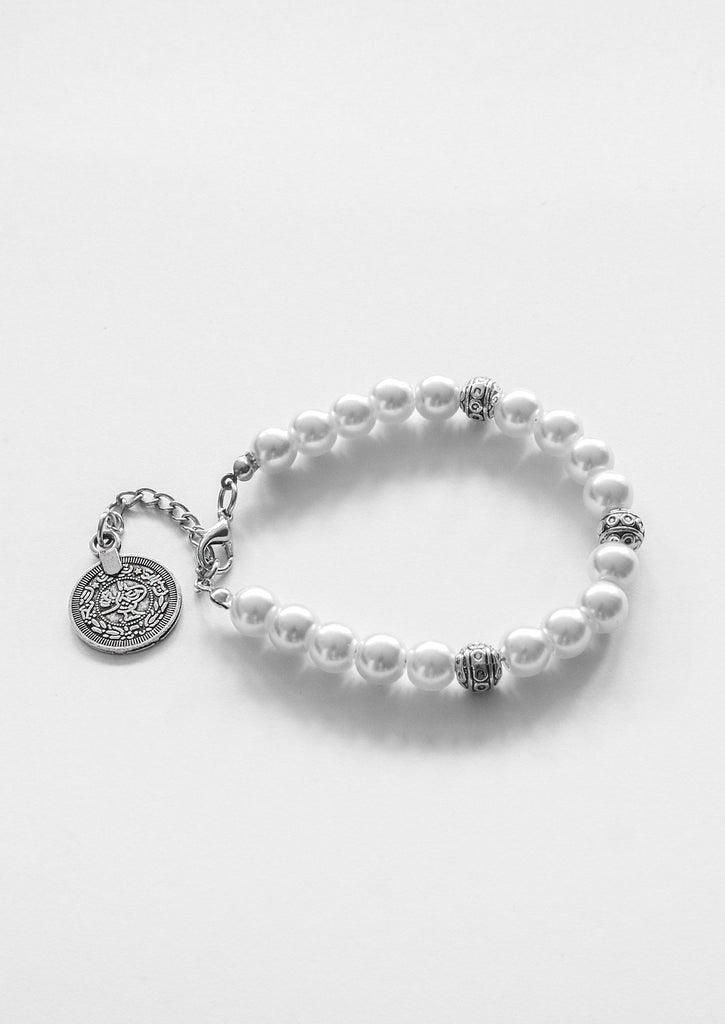 flat lay gypsy coin white bracelet on white background  